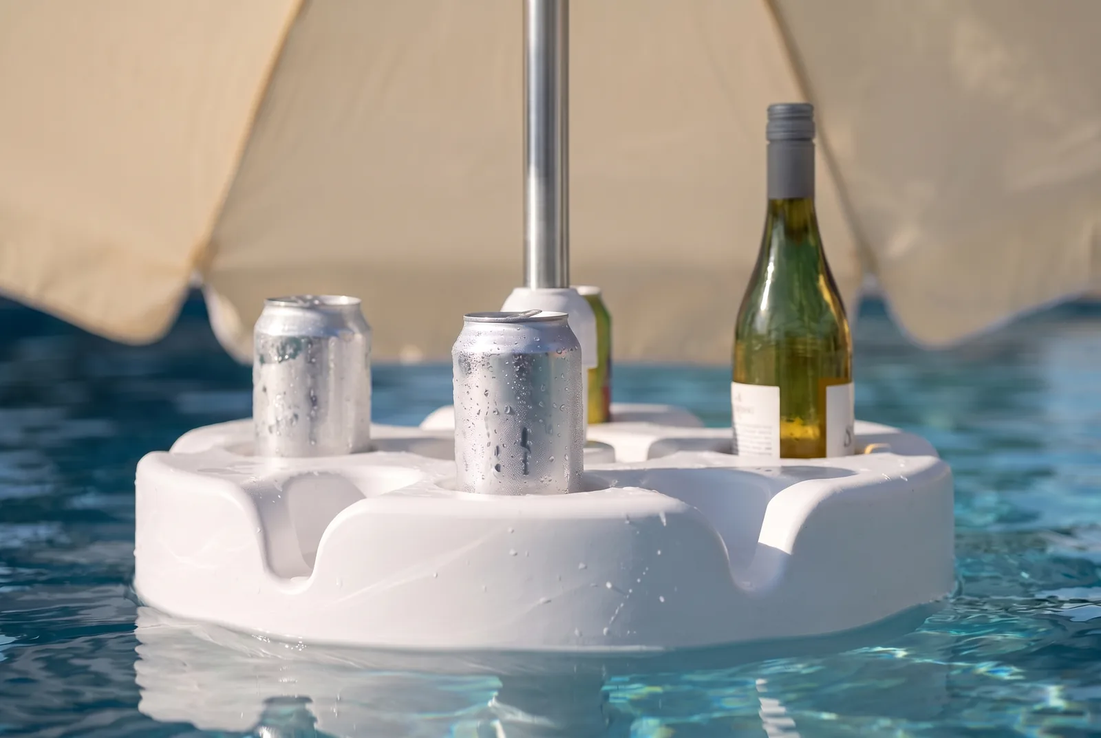 Close-up of cold cans and a bottle standing in the FloatMate table's moulded drink recesses
